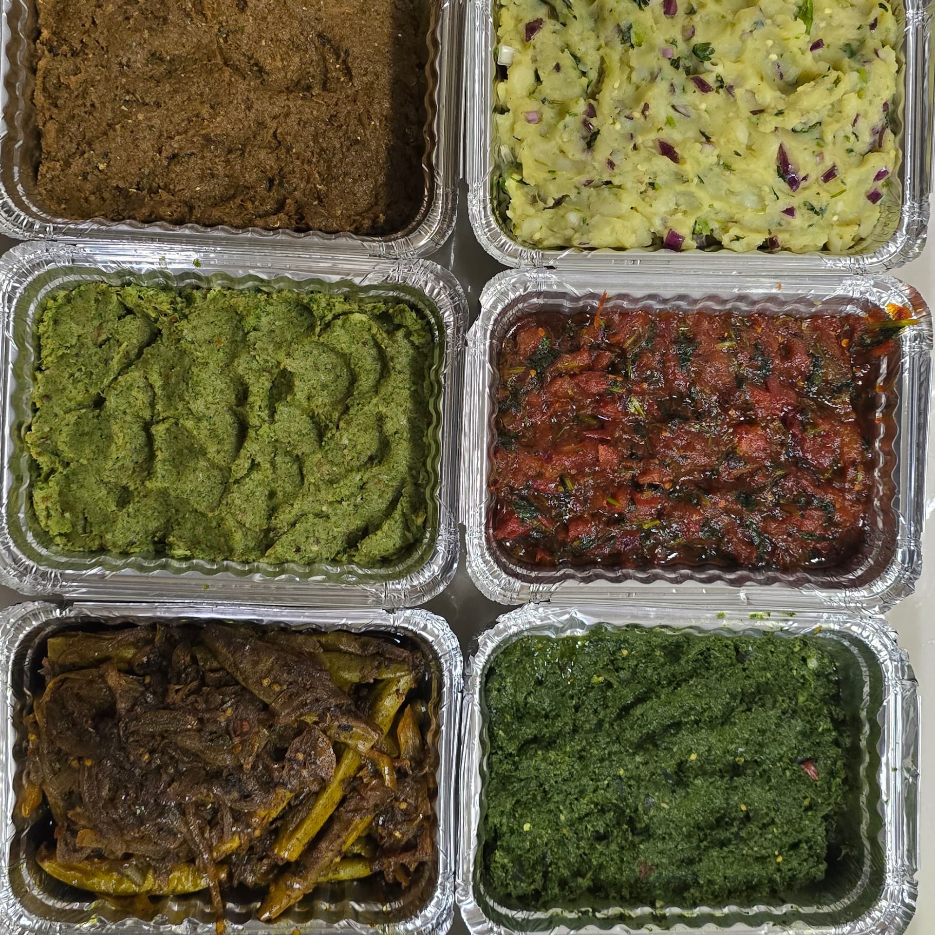 Bangladeshi vorta platter on a banana leaf with green chilies and lime