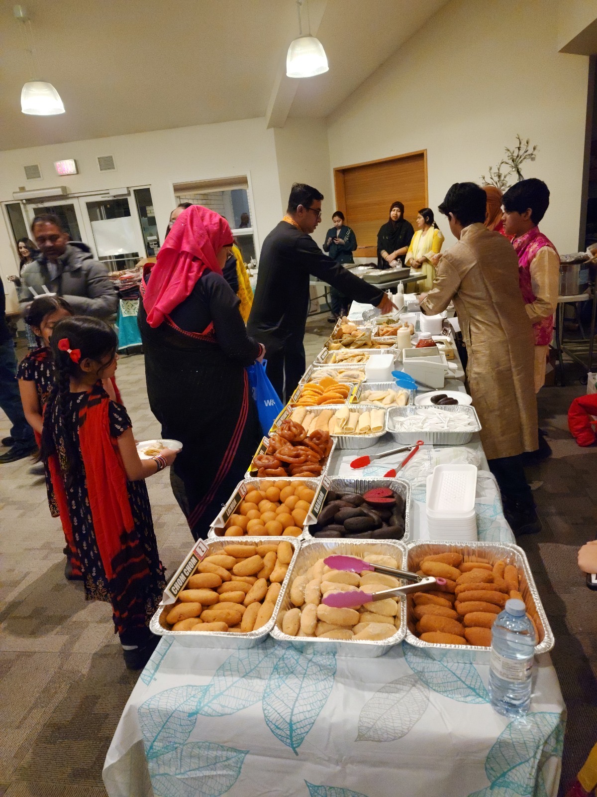 Trays of traditional Bengali sweets and pitha at an event