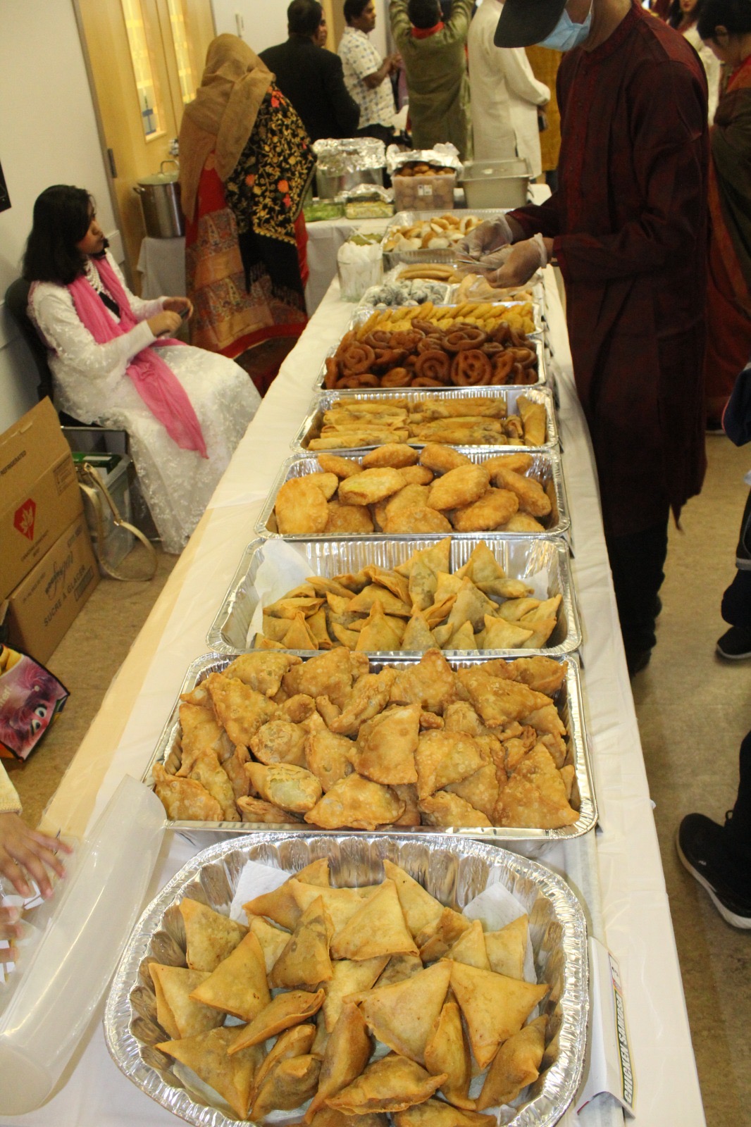 Long table of fresh samosas and savoury snacks for catering